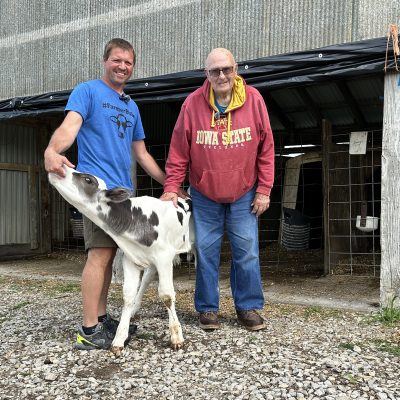 Hadwen Kleiss, age 93, stands with Blake Hansen and a calf that was produced with semen from Kleiss's prized bull of the 1980s.